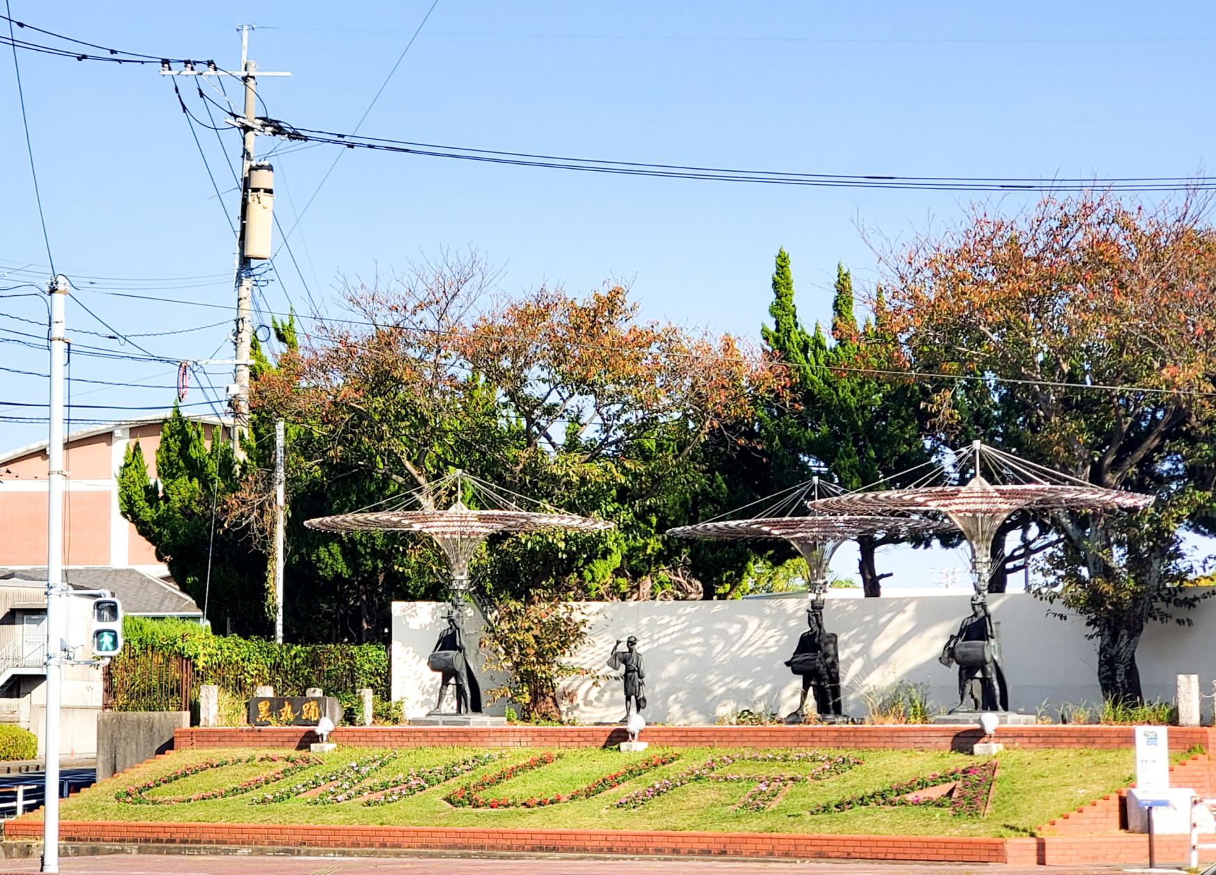 公園そばの交差点向こう側にあるのはOMURAの花文字と黒丸踊の像-1